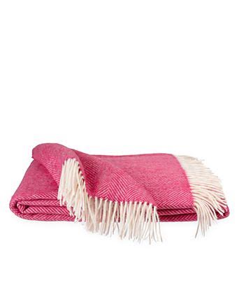 Pink herringbone knit scarf with white fringe trim, folded on a white background.