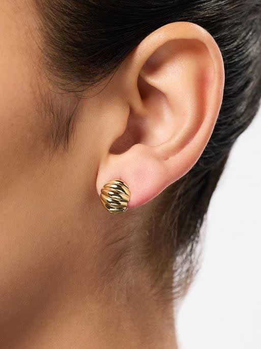 Mini statement earrings with a bold textured gold finish on brass hoops.