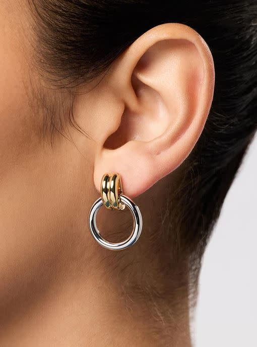 Mixed-metal statement earrings with rhodium silver and gold rings on a stainless steel post.