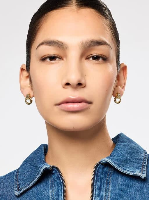 Chunky gold-plated brass statement earrings featuring multiple stacked rings on a stainless steel post.