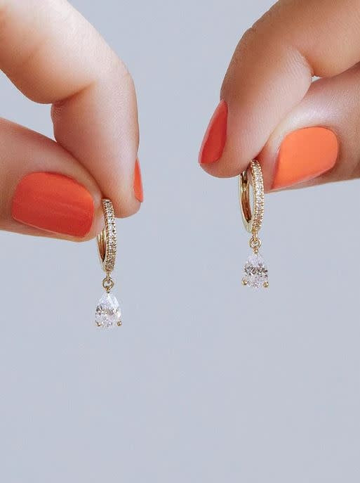 Gold-dipped huggie hoop earrings with cubic zirconia gems on a surgical steel post.