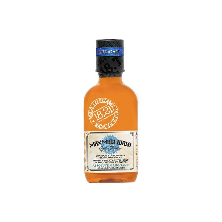 Travel-size bottle of Man Made Wash in a clear container with blue liquid.
