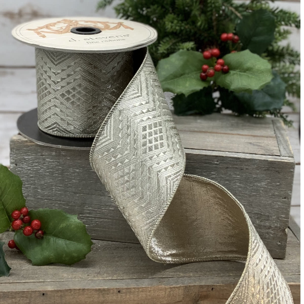 Platinum metallic jacquard ribbon with an Art-Deco geometric pattern on a spool.
