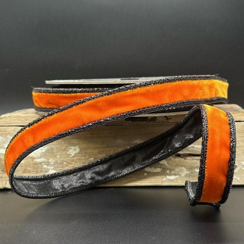 Orange velvet ribbon with black braided edges on a spool, 1 inch wide.