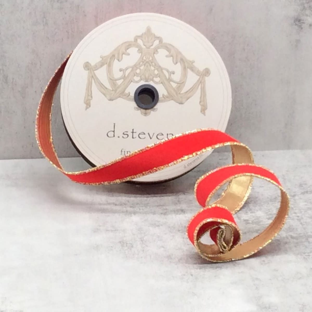 Red flocked velvet ribbon with metallic gold edges on a d.stevens spool.