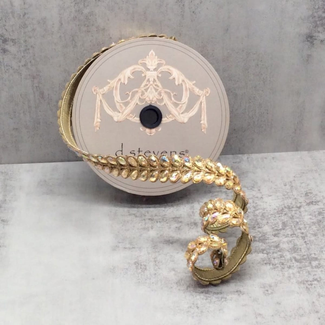 Gold ribbon with aurora borealis jewel-encrusted honey locust leaf pattern on a d. stevens spool.