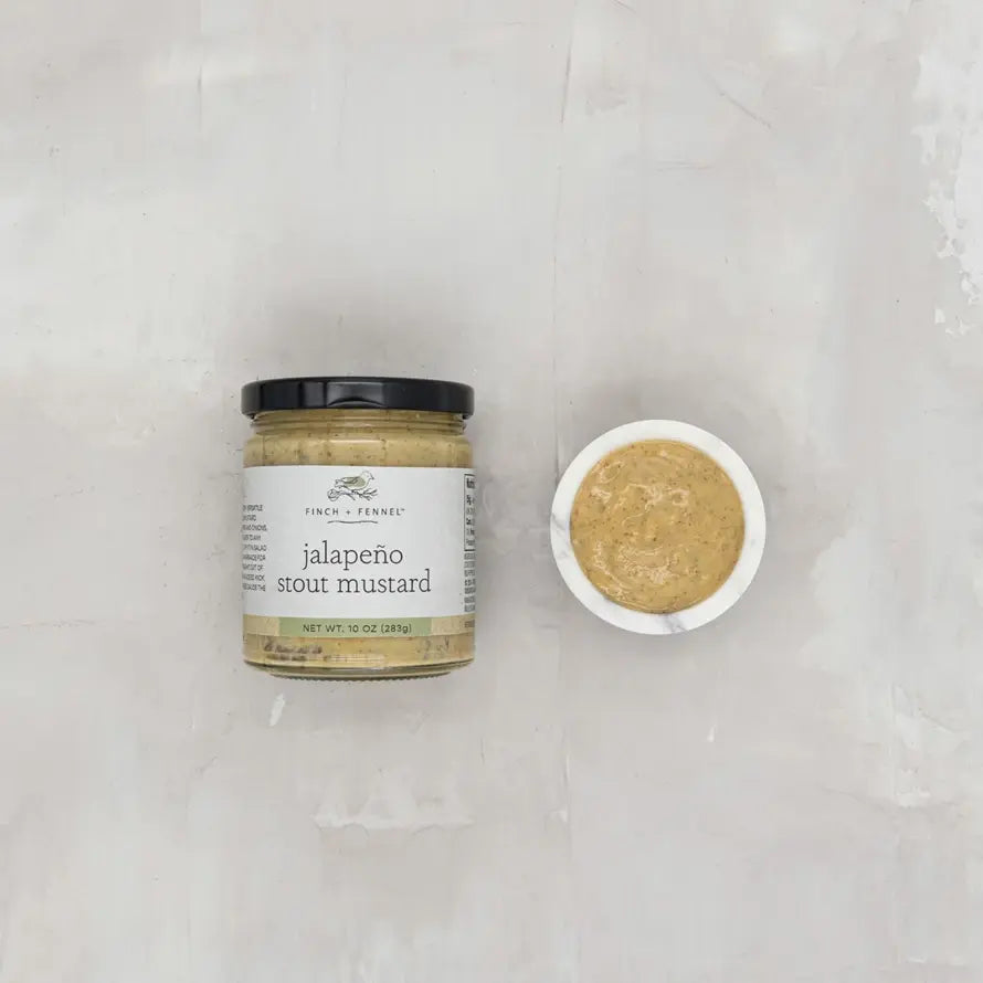 A jar of Finch + Fennel Jalapeño Stout Mustard next to a small bowl of the mustard.