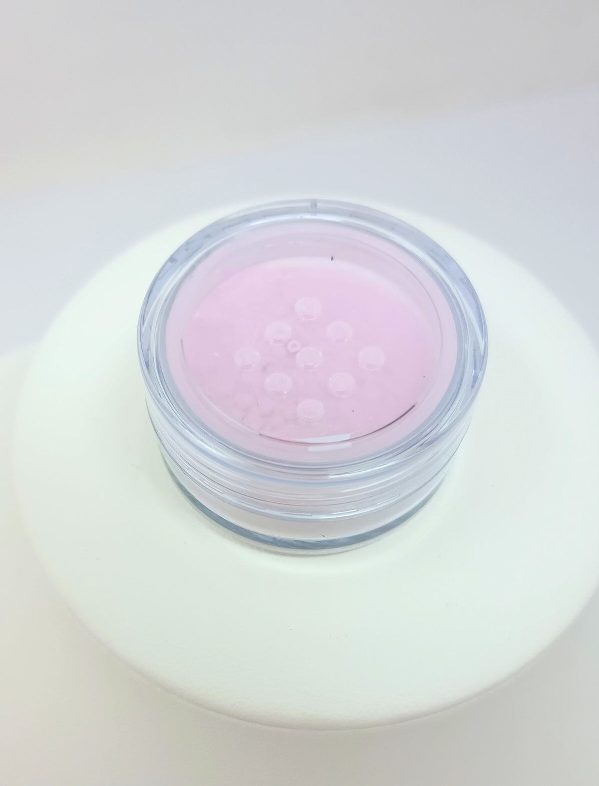 Under Eye Brightening Powder in a compact container with light-colored powder visible.