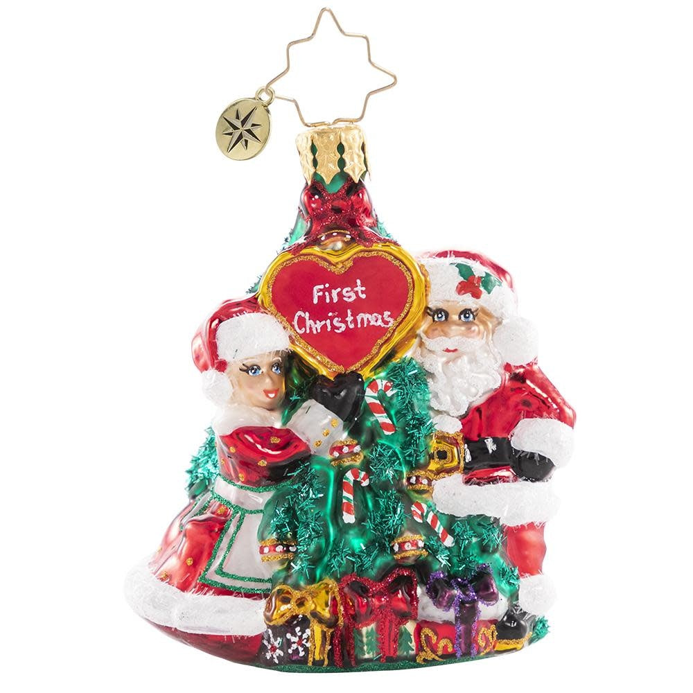 Ceramic ornament shaped as a couple in red coats with green holly accents.