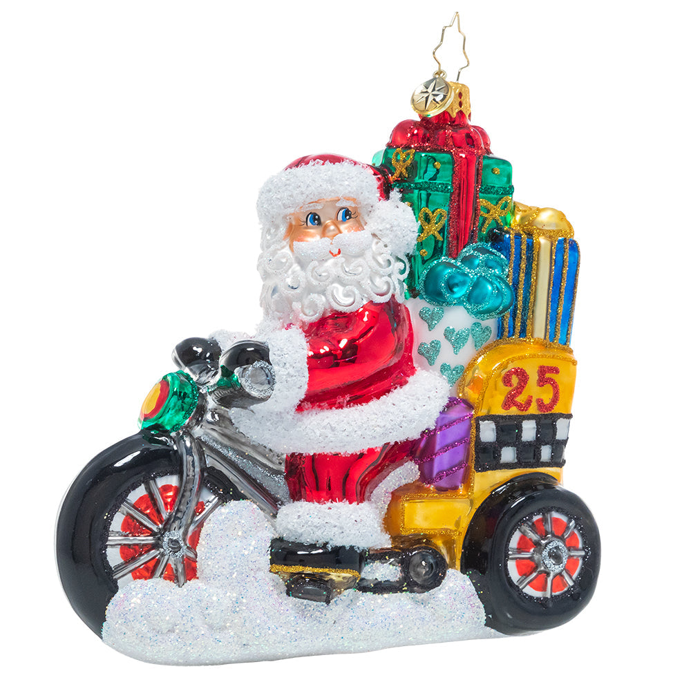 Santa Claus pedicab figurine in red with green accents carrying Christmas gifts.