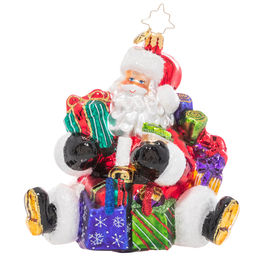 Santa figurine with arms full of wrapped gifts in red suit