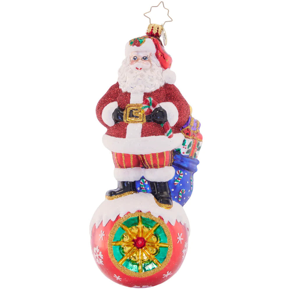 On Top Of It Santa figurine in red suit with white beard standing on a green hill.