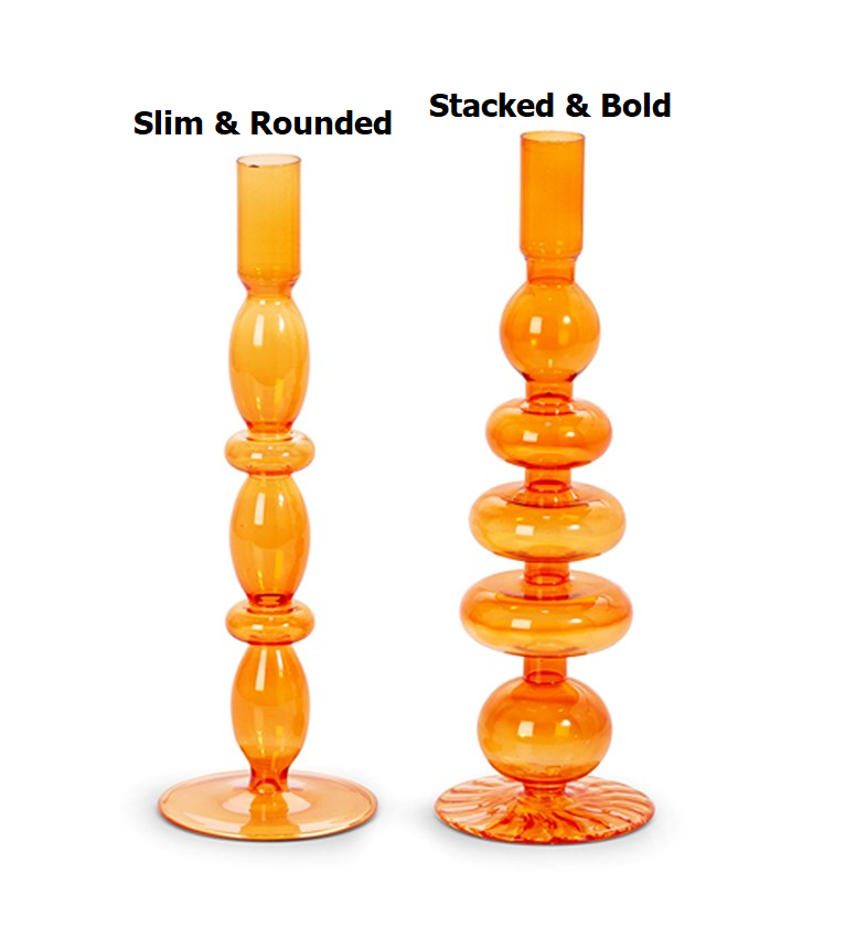 Two orange glass candle holders with distinct stacked, rounded silhouettes on a white background.
