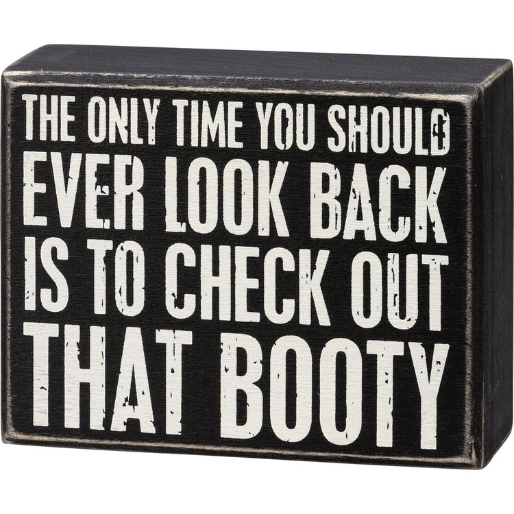 Wooden box sign with black text on white background reading 'The only time you should ever look back is to check out that booty'.
