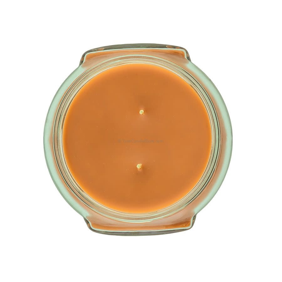 Top-down view of an 11oz Tyler candle in a glass jar with orange wax and two wicks.