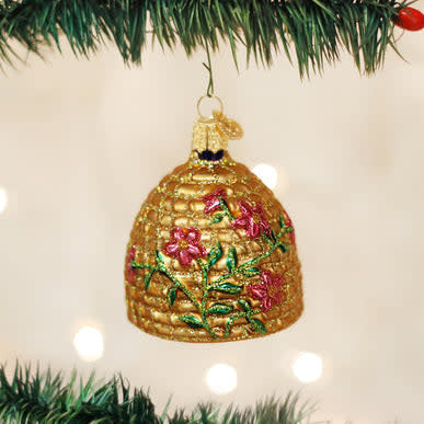 Glass bee skep ornament in coiled straw shape with natural tan color.