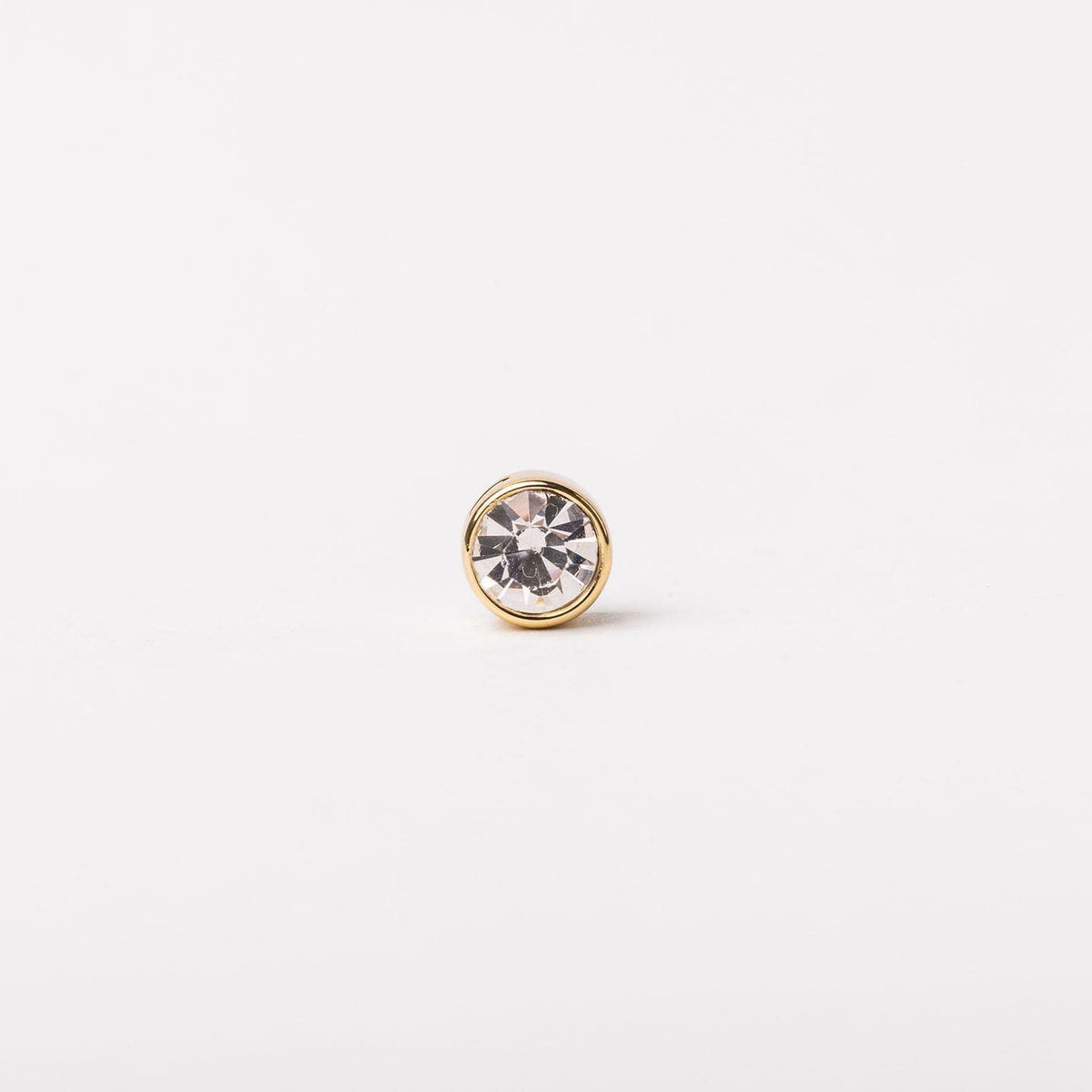 Gold-tone bezel-set stud earring featuring a clear round-cut crystal center.