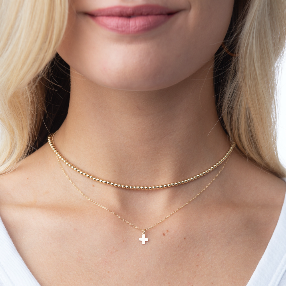 Classic gold choker necklace featuring a continuous strand of small round beads.