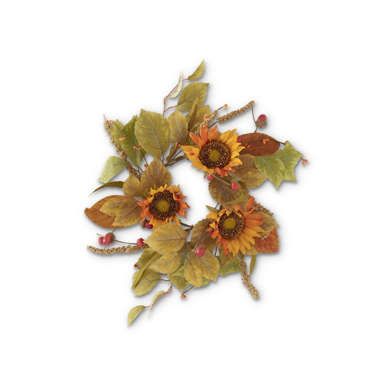 Orange sunflower candle ring with mini pumpkins and berry spikes on a table.