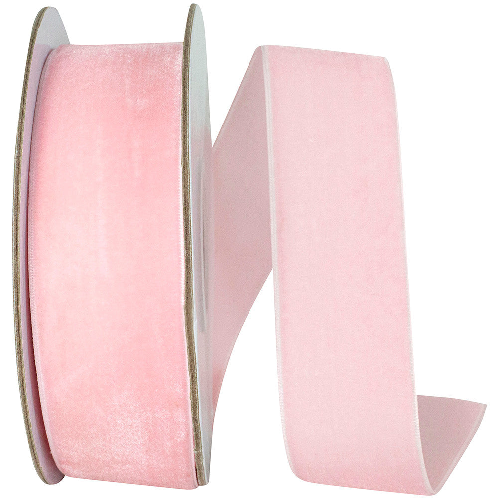 Roll of light pink woven edge velvet fabric with a soft texture.