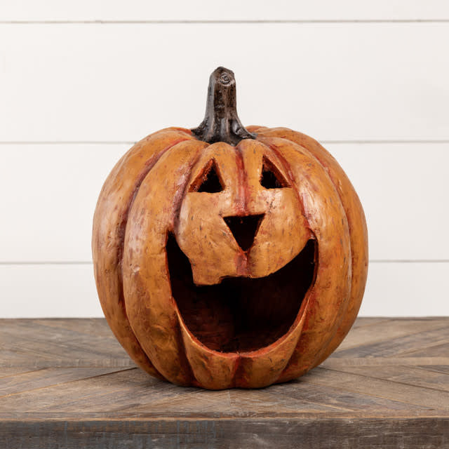 Orange mache pumpkin luminary with a large mouth cutout