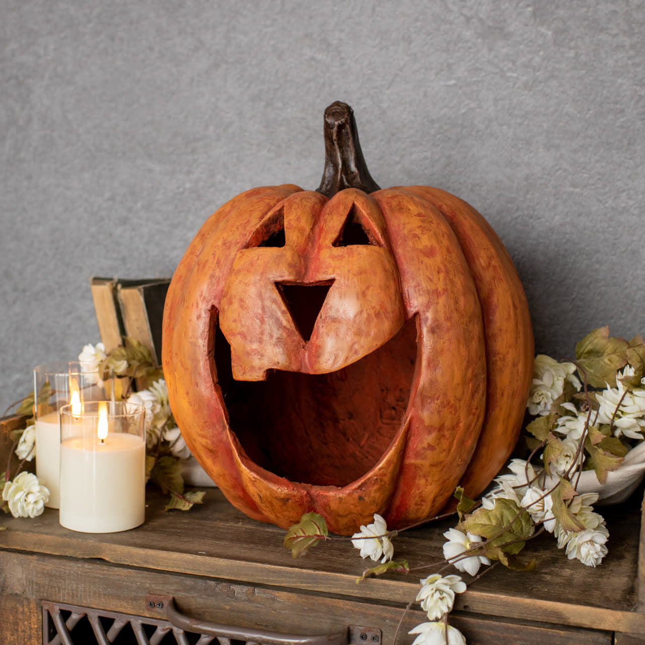 Orange maché pumpkin luminary with a large mouth cutout