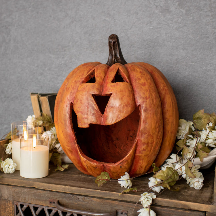Orange maché pumpkin luminary with a large mouth cutout