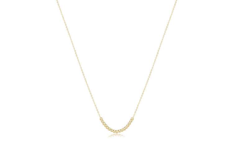 Gold classic beaded necklace with a clarity charm pendant on an adjustable chain.