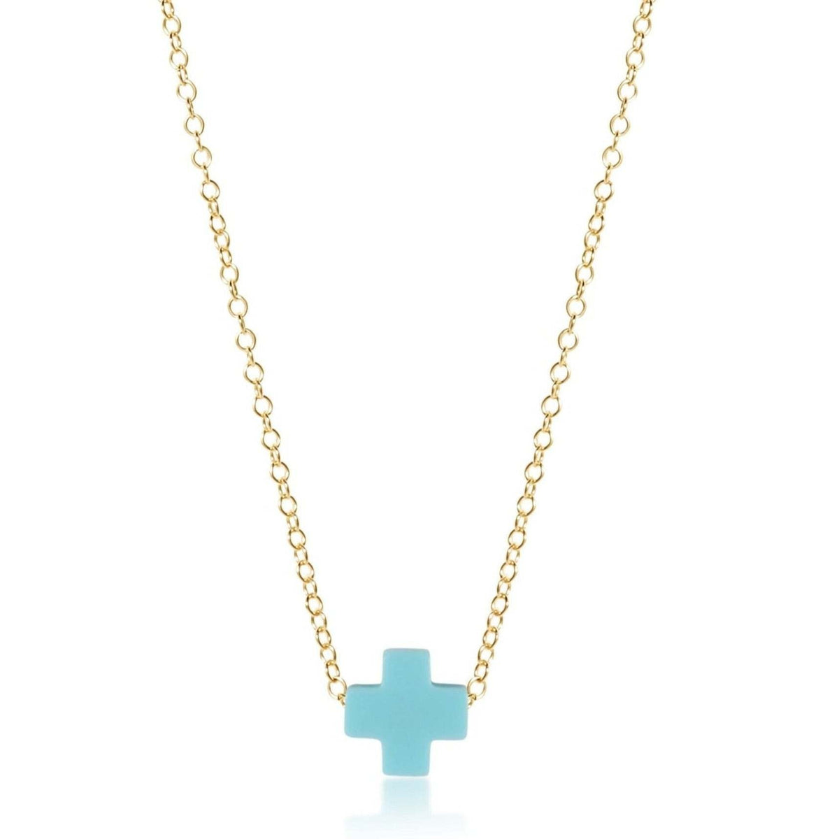 Gold-filled necklace with a signature cross pendant on a turquoise background