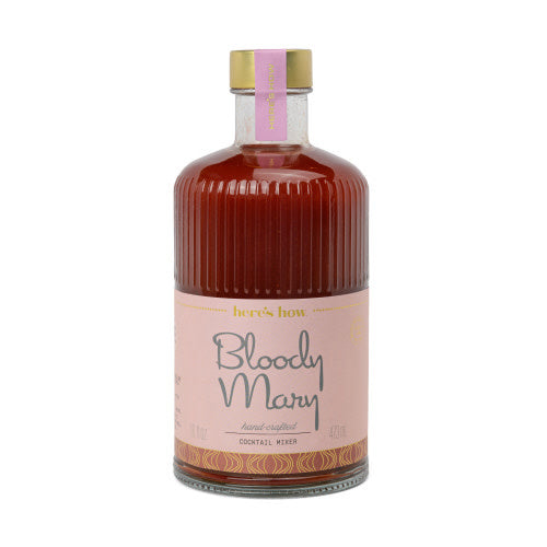 Custom embossed fluted glass bottle containing red cocktail mixer with gold foil label.
