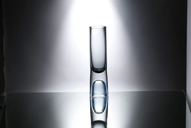 Clear glass cylinder vase with square cross-section measuring four inches wide by seven inches tall.