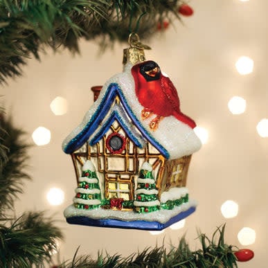 Red cardinal birdhouse ornament with cottage roof perched on a branch