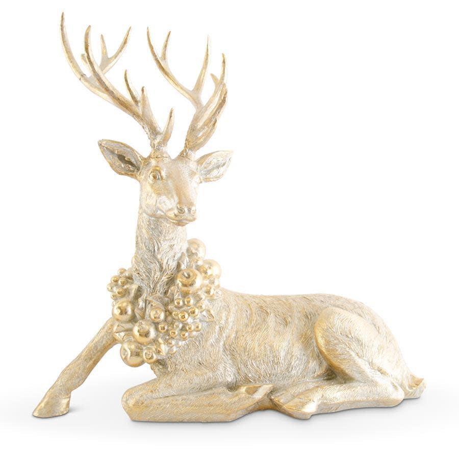 Antique gold resin deer figurine in a laying pose with a decorative fruit wreath around its neck.