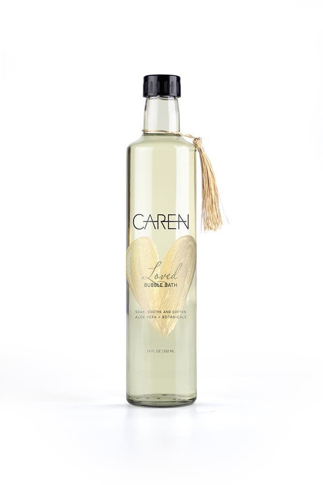 Glass bottle containing Loved Bubble Bath in Seaside scent with creamy suds.