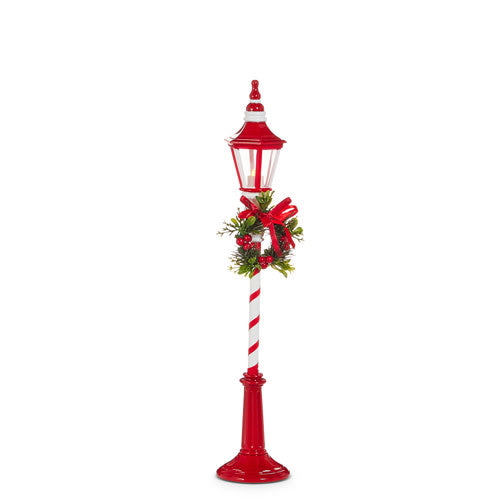 Red and white plastic lamp post with lighted festive design