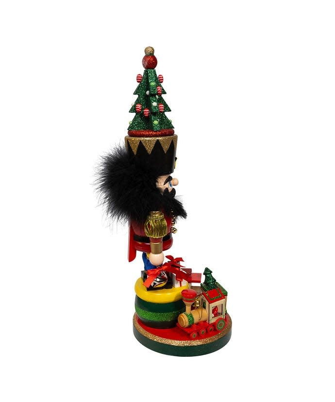 Wooden Hollywood nutcracker with toy train base in festive attire featuring a tall Christmas tree hat.