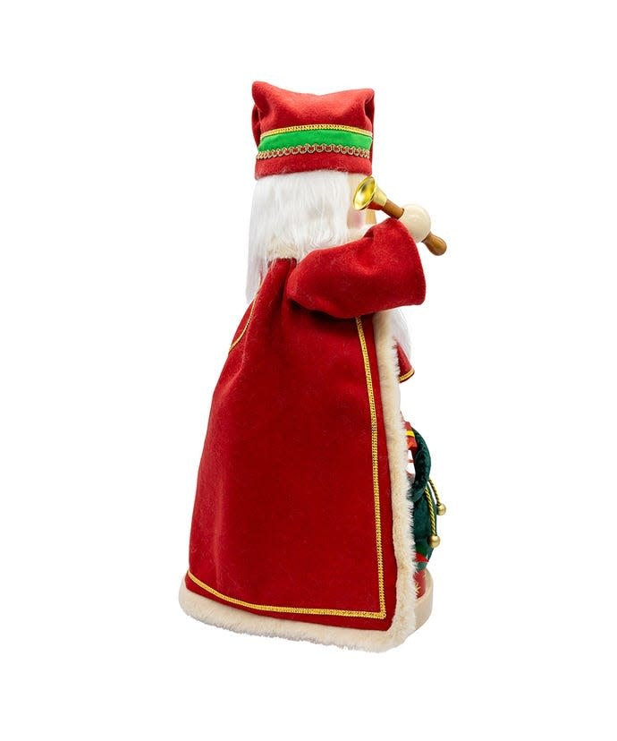Wooden nutcracker shaped as Santa in red with fur trim holding a North Pole staff