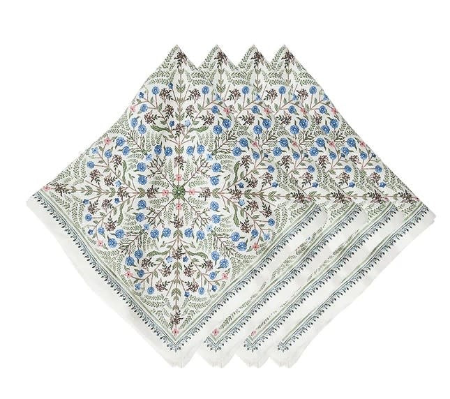 Set of four Villa Seville linen napkins featuring painterly green, blue, and pink floral patterns with delicate garland trim.