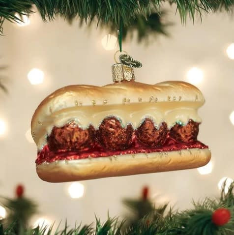 Wooden ornament shaped like a meatball sandwich with visible bread layers.