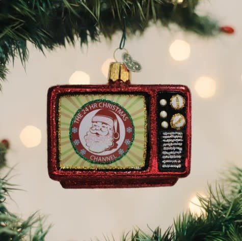 Glass Christmas ornament with a traditional red bell shape featuring gold accents.