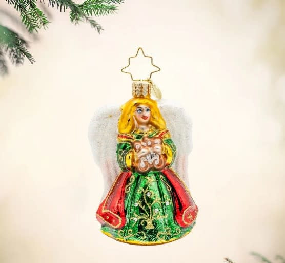 Small white ceramic angel figurine with harp wings and gemstone accents.