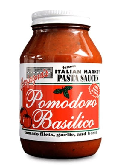 Glass jar of red Pomodoro Basilico sauce with visible basil leaves.