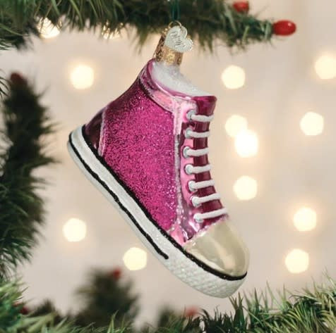 Black fashion sneaker ornament with white laces on a neutral background.