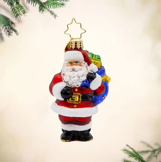 Red Santa Claus figurine with sack of sparkling presents