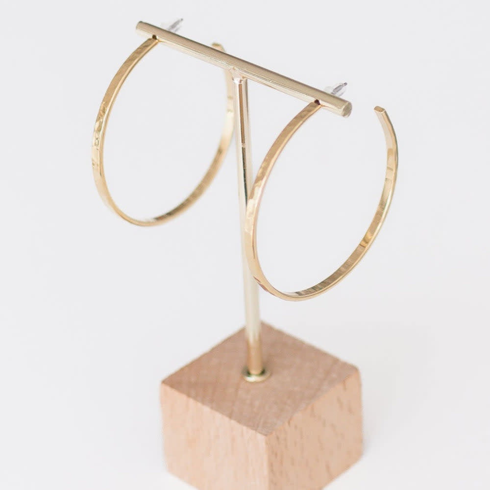 Handcrafted hammered gold hoop earrings with a textured finish.