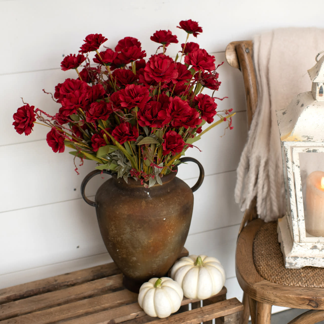 Artificial dark red camellia bush with mixed green foliage in a round silhouette made of polyester and plastic.