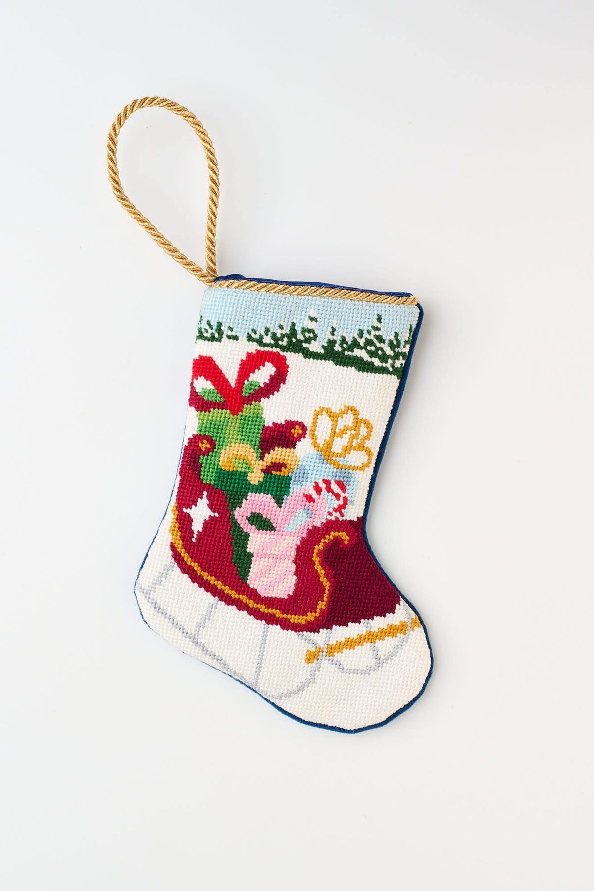 Hand-stitched needlepoint stocking with velvet backing in red featuring a Santa sleigh and bauble pattern.
