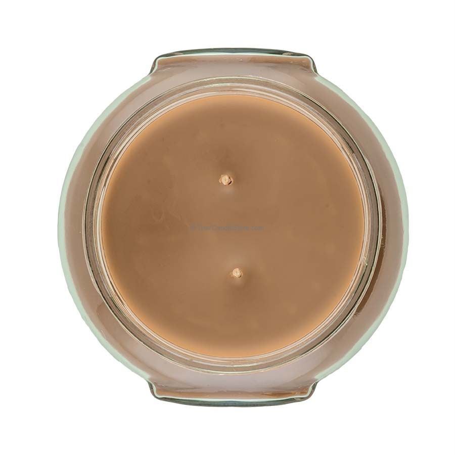 A 22oz Tyler candle in a clear glass jar with an off-white wax and black wick.