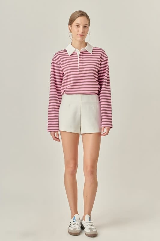 Pink striped rugby polo shirt with collar button neck, long sleeves, drop shoulders, and soft knit fabric in a relaxed modern fit.