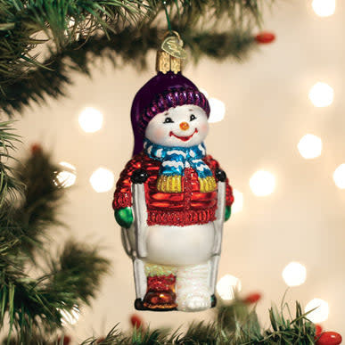 Snowman ornament with crutches standing on a patch of ice.